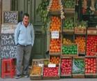Продавец фруктов и овощей в своем магазине